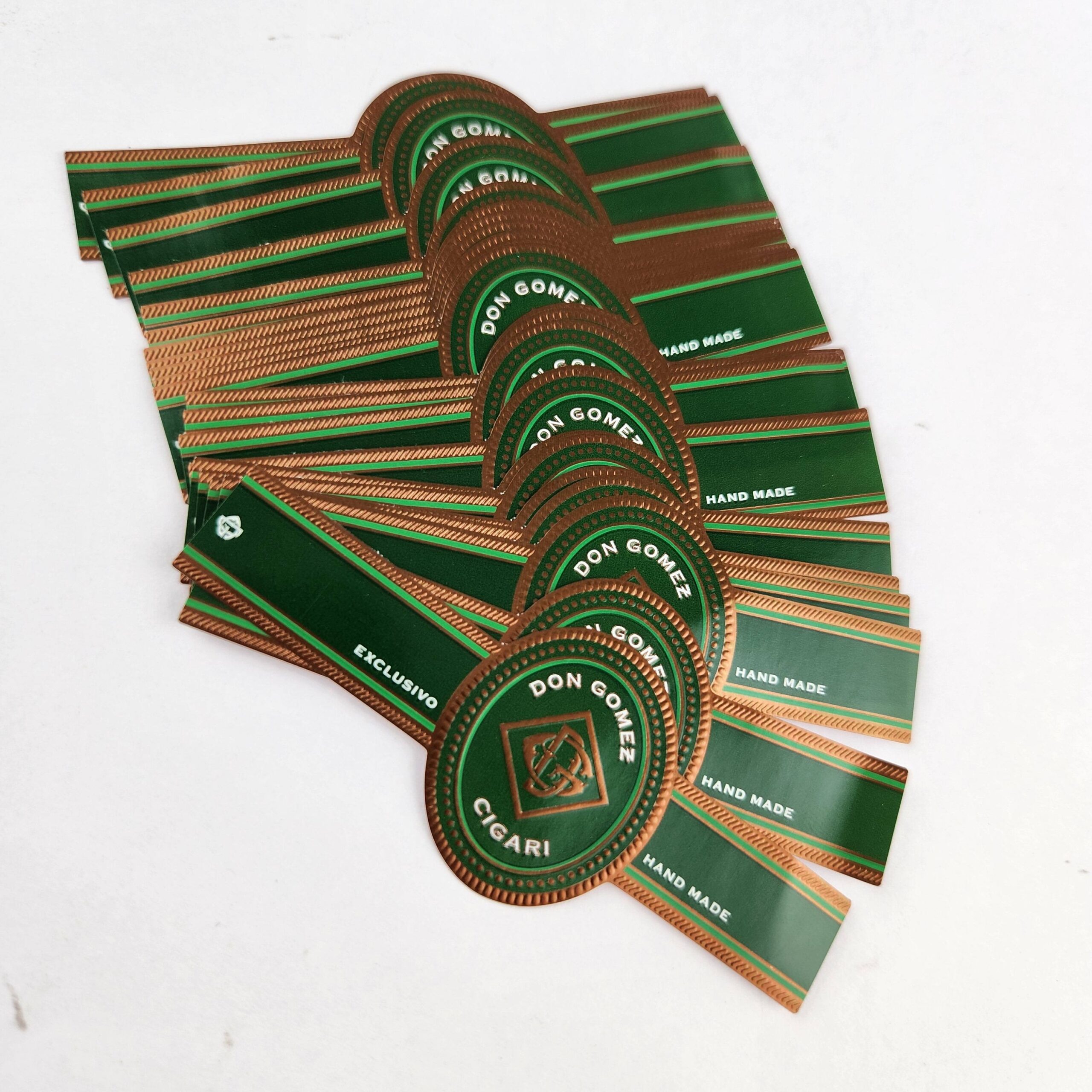 Custom cigar bands with gold foil embossing arranged as a premium product sample